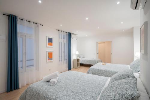 马德里Room Plaza España的白色的客房设有两张床和窗户。