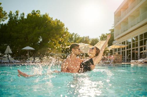 波尔布鲁笋波拉克酒店的坐在游泳池里的男人和女人