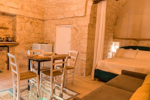 切列梅萨皮卡La Casedda - Apartment & Hydromassage的配有一张床和一张桌子及椅子的房间