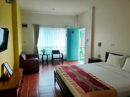 清莱班雅鲁酒店的一间卧室配有一张床、一把椅子和一张桌子