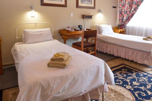 德尔斯特鲁姆Dullstroom Inn的酒店客房 - 带两张床和毛巾