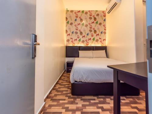 马六甲Gold City Hotel的小房间设有一张床和一张桌子