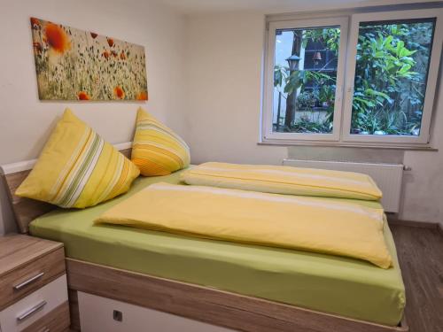 特赖斯-卡尔登Ferienwohnung Zilliken的一间卧室设有两张带黄床单的床和窗户。