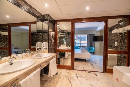 维戈Hotel Bahía de Vigo的一间带两个盥洗盆和大镜子的浴室