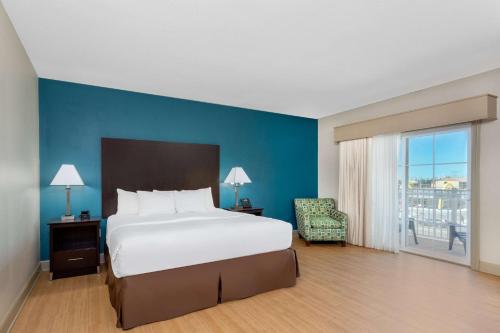 大洋城海洋城拉金塔旅馆及套房酒店的一间卧室设有一张大床和蓝色的墙壁