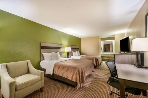 加兰加兰品质酒店的酒店客房,配有两张床和椅子