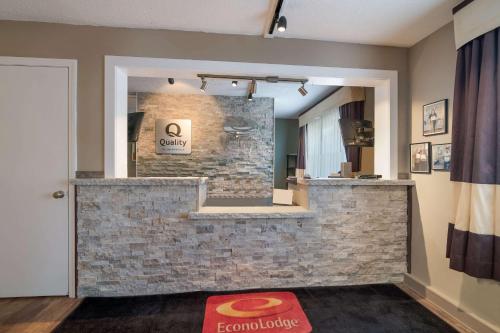 奥本Quality Inn & Suites的大堂设有石墙和镜子