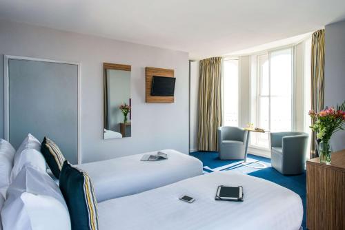 布莱克浦Forshaws Hotel - Blackpool的一间酒店客房,设有两张床和电视