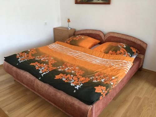 BukovinaApartmány Smrečie的床上有橙色毯子