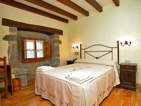 Baró卡瑟纳巴罗旅馆的一间卧室设有一张床和石墙
