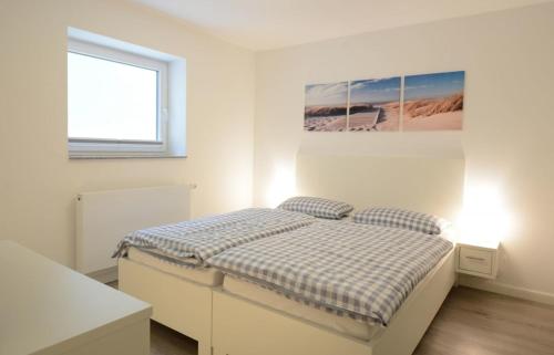 威克奥夫弗尔Haus Katharina links的白色的卧室设有床和窗户