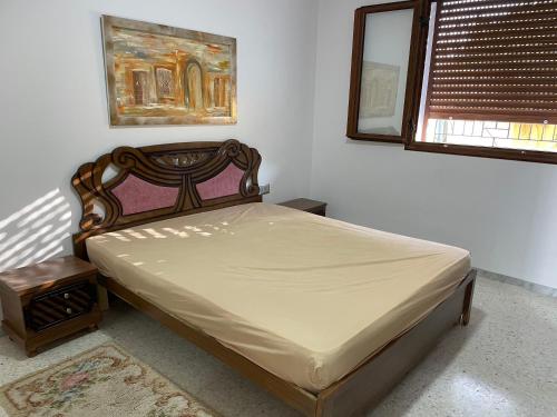 乌姆苏克Zahra 1的一间卧室配有一张床、镜子和窗户