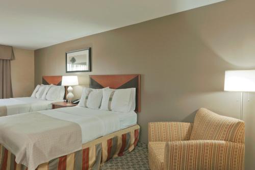 卡本代尔代尔假日酒店 - 会议中心 的酒店客房,配有两张床和椅子