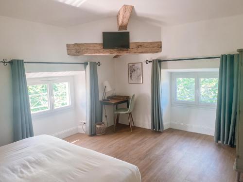 吕奥姆萨维尔酒店的卧室配有一张床、一张书桌和窗户。