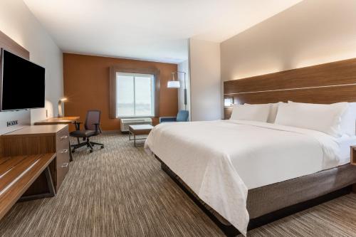 KearneyHoliday Inn Express & Suites Kearney, an IHG Hotel的一间酒店客房,配有一张大床和一台平面电视