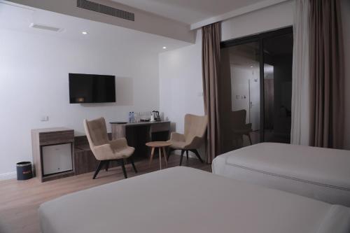 亚的斯亚贝巴Elmos Hotel的酒店客房带一张床、一张桌子和椅子