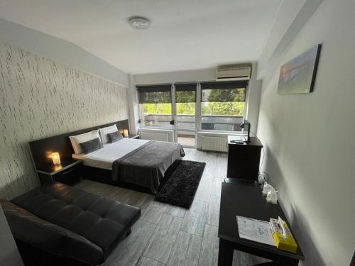 布加勒斯特Hotel Rivoli的一间卧室配有一张床和一个沙发