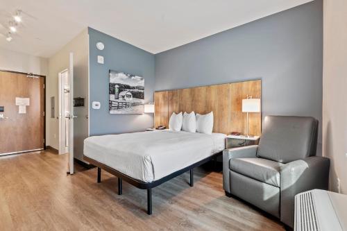 奥古斯塔Extended Stay America Premier Suites - Augusta的配有一张床和一把椅子的酒店客房