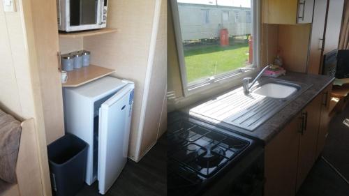 滨海克拉克顿Adorable 2 bedroom holiday home in Clacton-on-Sea的一间带水槽和冰箱的小厨房