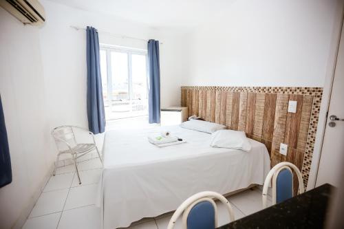 特雷西纳Hotel Barão Palace的卧室配有白色的床和窗户。