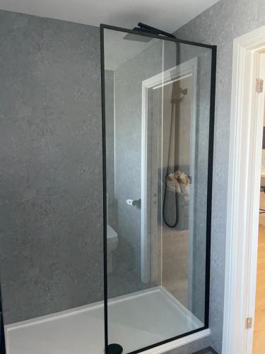 The Woodside Snug, Eastwell, Vale of Belvoir的浴室设有玻璃淋浴间。