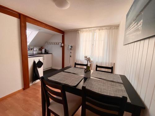 罗曼斯霍恩Apartment Romanshorn von Swisspartments的一间用餐室,配有黑色的桌子和椅子