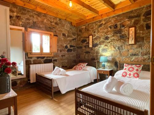 Cilleruelo de BezanaCasa Rural Puerto del Escudo的一间卧室设有两张床和石墙