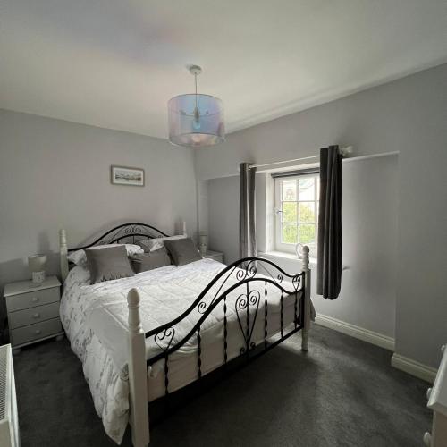 彭里斯Honeysuckle Cottage & Whinfell Studio的卧室配有白色的床和窗户。