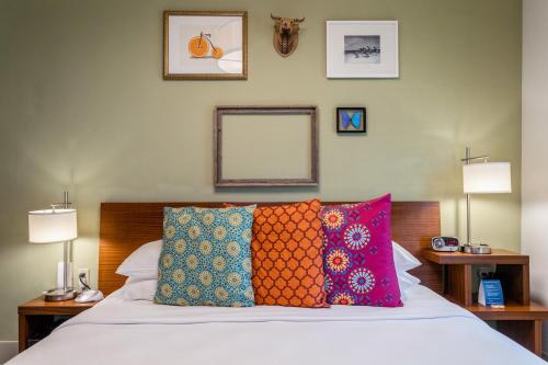 迈阿密海滩Kasa El Paseo Miami Beach的一间卧室配有带色彩缤纷枕头的床。