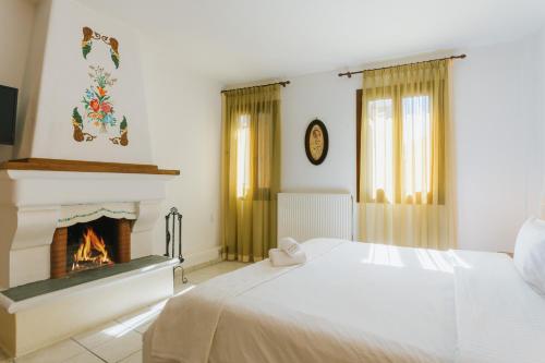 马克里尼撒Archontiko Anemos的一间卧室配有一张床和一个壁炉