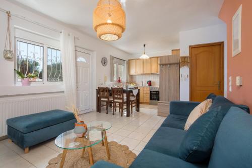 蒂锡利维Casa Callianeira Residence的一间带蓝色沙发的客厅和一间厨房