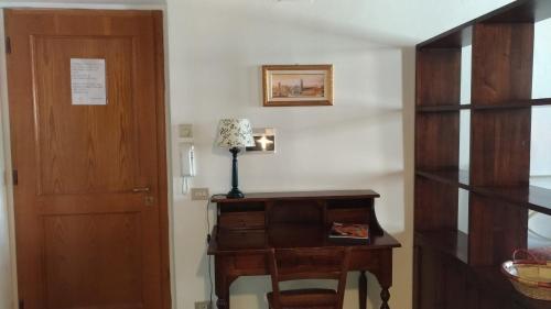 比萨多莫斯公寓的一间设有门的房间和一张带台灯的桌子