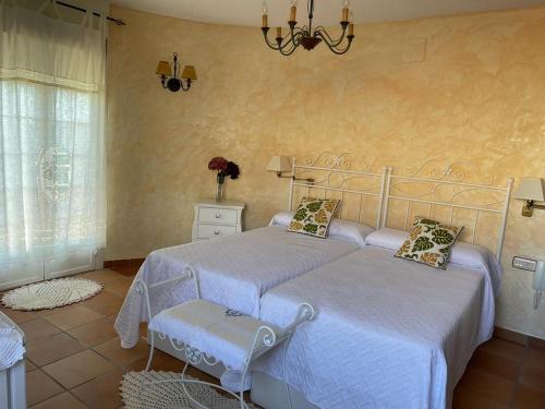 洛萨尔德拉韦拉CASA SEBASTIANA SUITE的一间卧室配有两张床和吊灯。