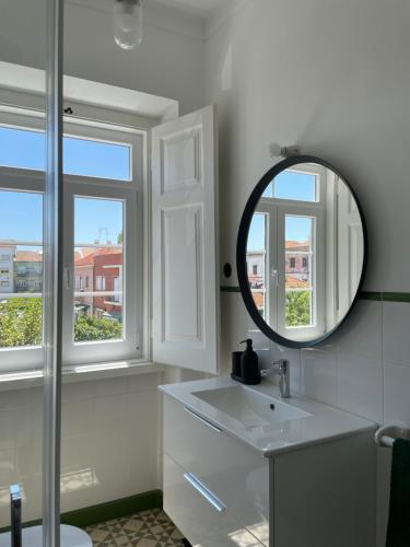萨尔堡Casa do Mercado的浴室设有镜子、水槽和窗户