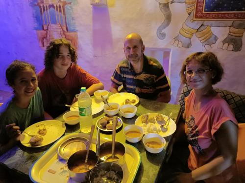 本迪Bhavyam HomeStay &Cafe BackPackers ko的一群人坐在桌子旁吃着食物