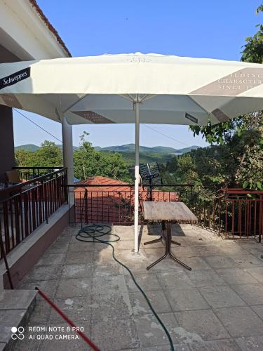 KryonérionHouse on the mountain的庭院内的白色遮阳伞和长凳