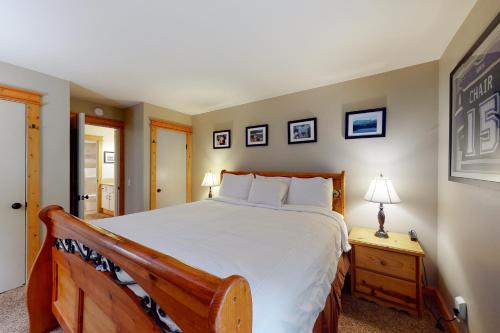 老猛犸湖The Summit 206的一间卧室配有一张大床和一张带台灯的桌子