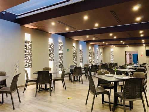 墨西哥城Hotel Ritz Ciudad de México的一间在房间内配有桌椅的餐厅