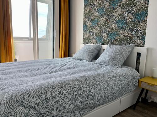 库尔瑟勒·苏尔·梅尔Appt centre de Courseulles - 100m de la plage的一间卧室配有一张带蓝色和白色棉被的床