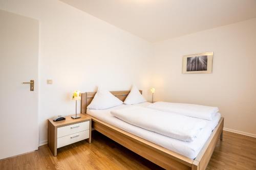 施莱登索尔兹伯格穆德弗里恩公园酒店的一间卧室配有一张带白色床单和一张桌子的床。