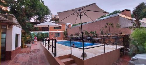 伊瓜苏港Charaí Lodge的一座带游泳池和遮阳伞的房子