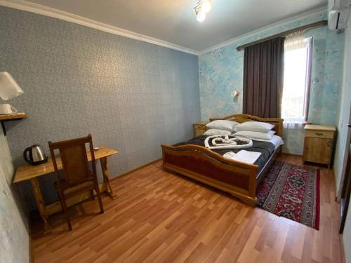AreniLiViTi的卧室配有1张床、1张桌子和1把椅子