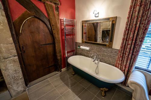 拉夫堡坎贝尔酒店的带浴缸和镜子的浴室