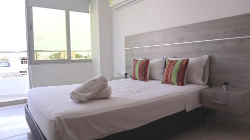 里奥阿查D Río Apartamentos的一张白色的床,上面有一条毛巾