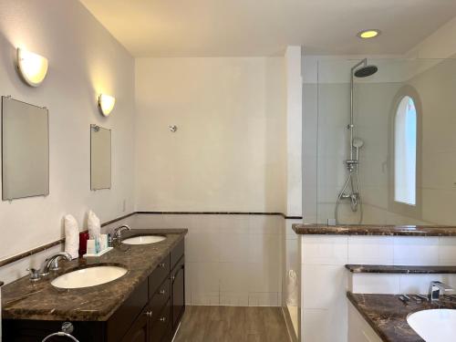 菲利普斯堡The Hotel Porto Cupecoy的一间带两个盥洗盆和淋浴的浴室
