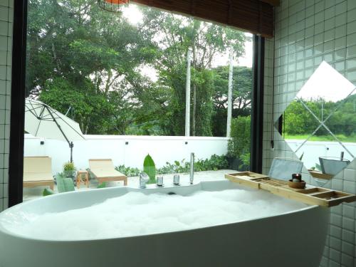 慕斯Sleep private khaoyai的一间带大窗户的浴室内的大浴缸
