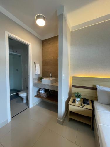 维多利亚Flat PRAIA Home Experience Dante Michelini的一间带床、水槽和卫生间的浴室
