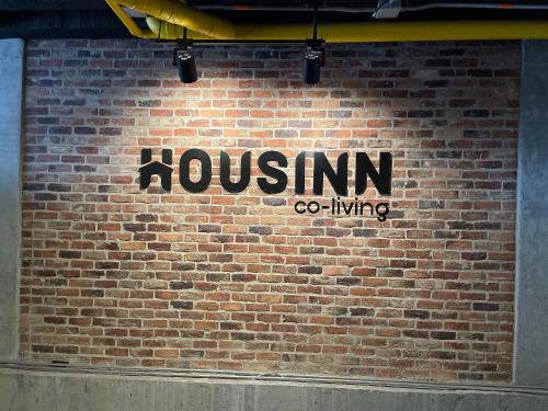 麦德林Housinn co-living Fatima en Medellín的砖墙边的标志