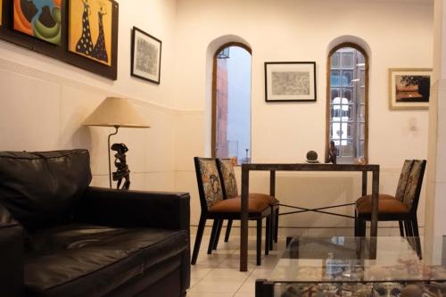 亚松森Giuseppe Suites Hotel的客厅配有沙发和桌椅