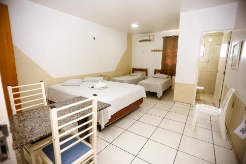 特雷西纳Hotel Barão Palace的酒店客房设有两张床和淋浴。